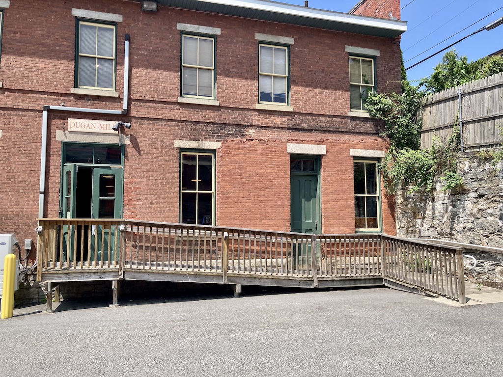 Dugan Mill first floor accessible entrance as viewed from parking lot. The minimum opening of the door is about 22 inches (0.56m) with one door open, and 44 inches (1.12 m) with both doors open.