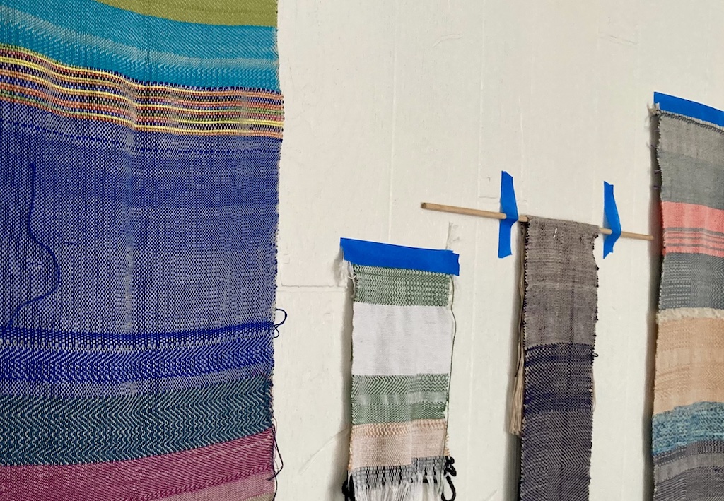 A variety of samplers on the wall of the Museum's weaving studio