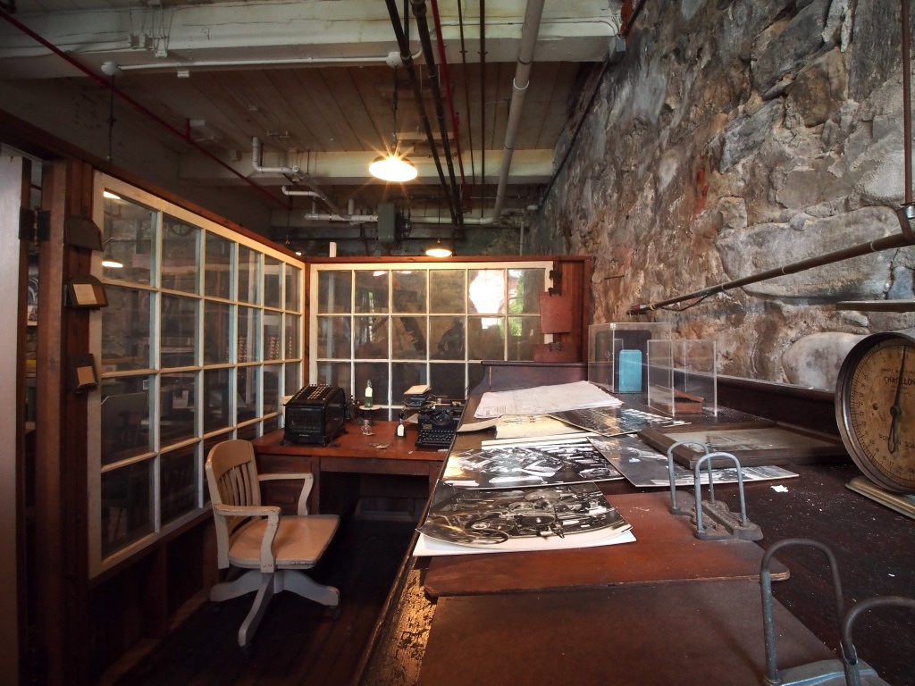 A photograph showing an example of the supervisor's area in the thread mills.  This exhibit is also used to showcase engineering-related artifacts.